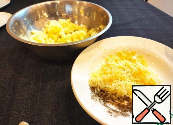 Mash the boiled potatoes, add the cheese grated on a fine grater, salt and pepper and mix everything thoroughly until smooth