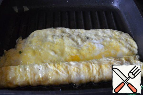 Carefully twist the roll, leaving a small "tail" of the omelet, it is convenient to do this with a wide silicone spatula. I still twisted, but the photo did not work out, alas...