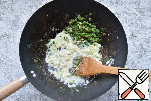 Pour the remaining amount of peanut butter into the pan and fry the onion with garlic and ginger paste. Push aside the greens. on the free edge of the pan, beat two eggs, fry, mixing them with a wooden spatula.