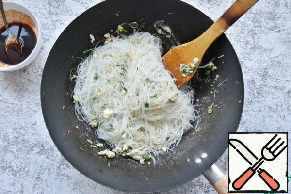 Add the prepared noodles, without reducing the heat, mix the noodles with herbs and eggs.