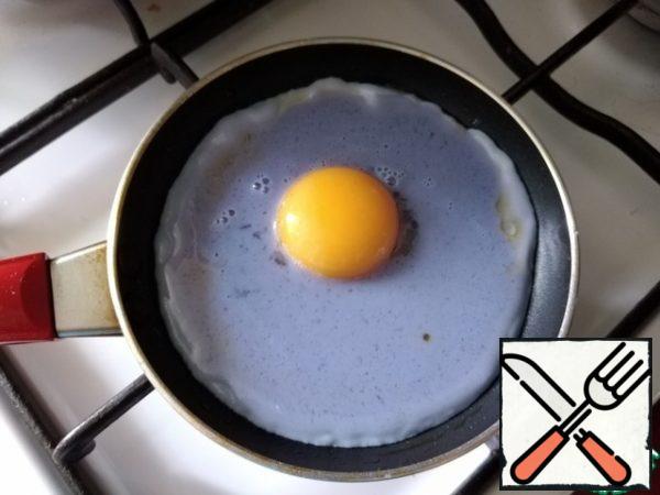 As soon as the mixture begins to set, carefully spread the yolk on top. Fry until tender. I like the yolk to remain viscous.