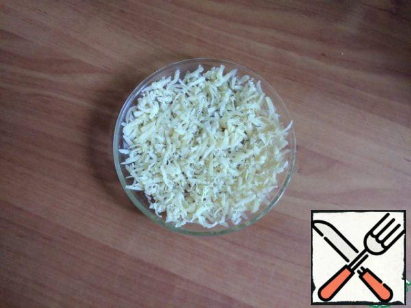 Take a standard saucer, lubricate it with any vegetable oil very thinly. Spread the grated cheese in a thin layer.