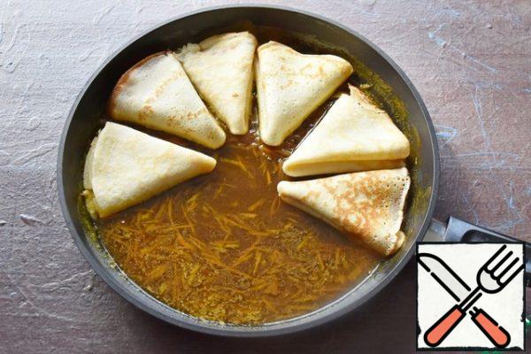Roll the crepes into triangles and put them in a frying pan with orange sauce. Warm up on one side and turn it over. Crepes should literally be soaked in fragrant orange sauce.
Serve pancakes with whipped cream or a ball of ice cream.

