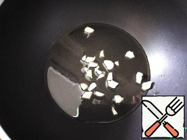 We take a saucepan, pour oil and heat it. Spread the garlic. Fry it for a minute so that it gives its flavor to the oil.