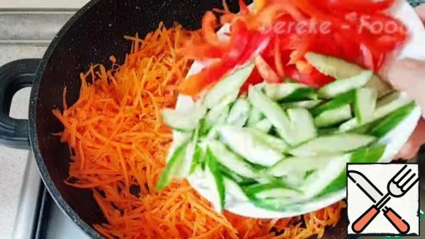 In a clean frying pan pour 30 ml of vegetable oil heat and put the chopped garlic fry over medium heat stirring and put the carrots mix, add soy sauce, salt, universal seasoning to taste and add cucumbers and sweet pepper mix well, close the lid and simmer over medium heat for 2-3 minutes.