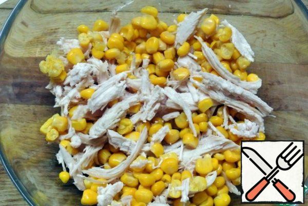 Strain the corn from the marinade. Put it in a salad bowl with chicken meat.