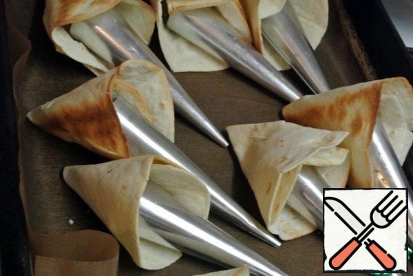 Roll up into bags. Fix it with a toothpick. Insert metal cones or foil cones inside so that the bags do not lose their shape when baking. Bake for 8 minutes at 200 C.