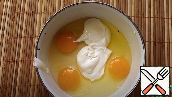 In another bowl, you need to make a batter. In a bowl, beat 3 eggs, and add sour cream 3 tbsp.  mix well. 