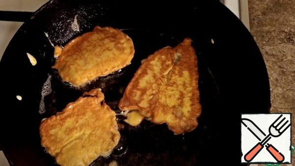 We lower each piece into the batter, and transfer it to a preheated frying pan, fry on both sides for 2 to 3 minutes, until the crust.
