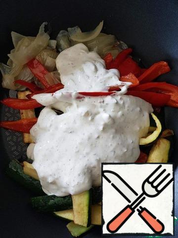 Put the fried vegetables in a frying pan without oil, add sour cream, mix well.
