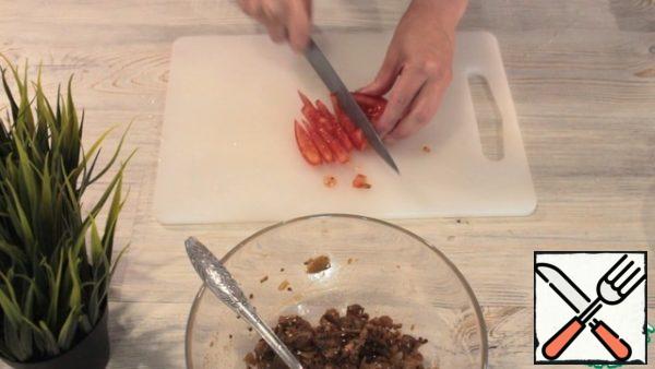 Next, add salt, paprika, garlic, sesame and oil. Mix it up. You can add lemon juice.
We take a tomato, remove the part where there is a lot of liquid. Cut into cubes.