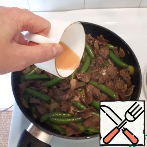 Now add the peas to the meat. Mix the water, starch and ketchup and pour into a frying pan, mix everything and warm up for another 2 minutes.