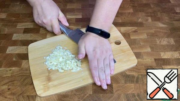 Crush the garlic and finely chop it.