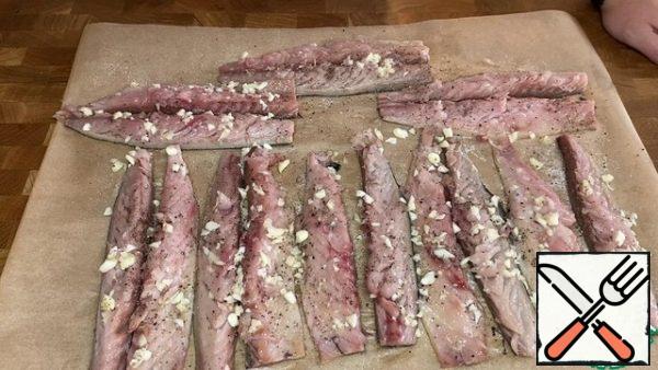 Cut each fillet lengthwise into two parts. Season the fish with salt, pepper, sprinkle with garlic and sprinkle with lemon juice.