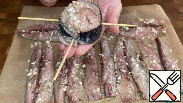 Twist the fillet with a roll, one fillet=one roll. Secure the roll with skewers.
In order for the skewers to easily enter the fish meat, they need to be scrolled around their axis. Place the finished rolls in a hot oven, heated to 240 degrees, for about 10-15 minutes.