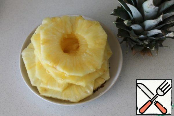Meanwhile, peel the pineapple and cut it into circles, removing the middle.