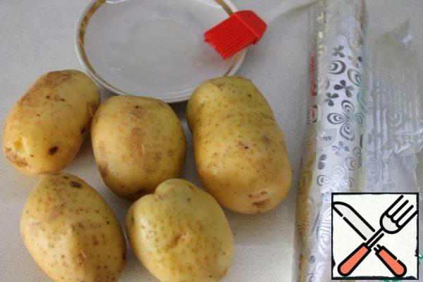 Potatoes need to be washed well, dried, pricked on top with a fork and lubricated on all sides with vegetable oil. It is convenient to do this with a brush. Then wrap each one in foil to get several layers and send it to the oven preheated to 180-200 degrees until ready. You can check it with a knife, carefully, without piercing through. The knife should gently enter the potatoes.