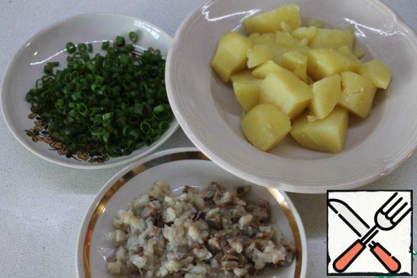 This snack is prepared very simply. Potatoes need to be cleaned, boiled, taken out of the water. Finely chop the herring and onion. Some pieces of herring should be left uncut, for decoration.
