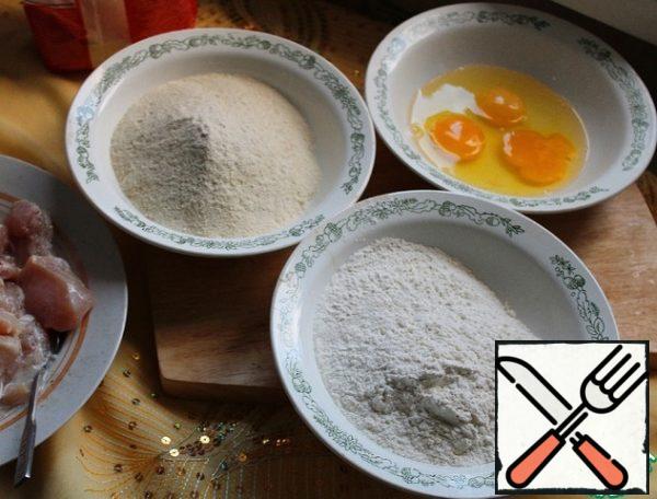 We take three bowls and pour the flour into one, breadcrumbs into the other, break the eggs into the third and beat them lightly with a fork.