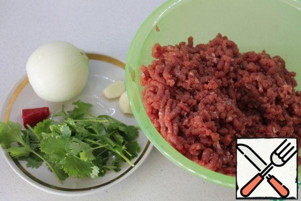 To prepare the cutlets, the beef must be twisted into minced meat. Then chop the onion, hot pepper and coriander (I also did it in a meat grinder), garlic on a garlic press.