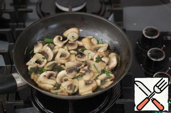 Heat the oil in a frying pan, fry the mushrooms with onions for five minutes, add a little salt, given that there will still be cheese in the omelet.