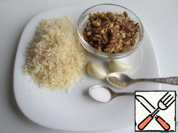 At this time, chop the walnuts in any convenient way, for example, put them in a cellophane bag and roll them with a rolling pin. Grate the parmesan on a grater (here - on a small one, if desired - on a large one). Prepare garlic, salt and black pepper.