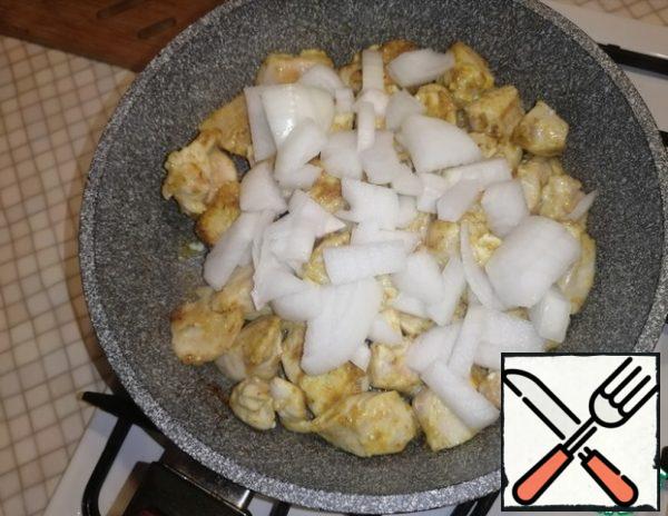 Cut the onion into large cubes, add to the pan to the chicken fillet.