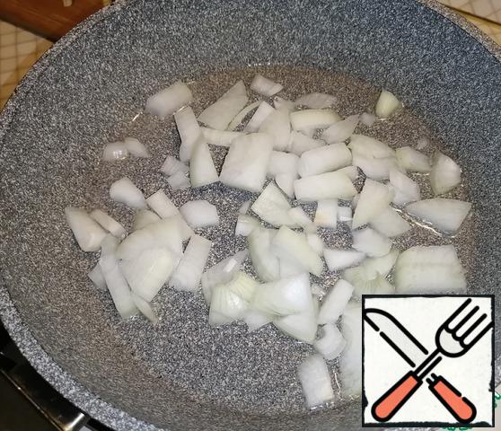 Cut the onion into cubes. Pour vegetable oil into a deep preheated frying pan and pour out the onion. Fry for 3-4 minutes, stirring occasionally.