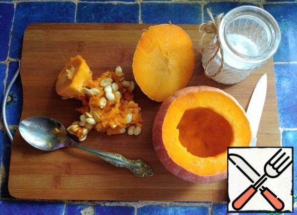 Since I have a small pumpkin, I weighed all the products for the recipe. I have a pumpkin in its unprocessed form of 600 g. We cut off the "lid" of the pumpkin and scoop out the seeds and membranes inside with a spoon, leaving the pulp on the walls. Inside the wall, add a little salt, rubbing salt with your fingers.