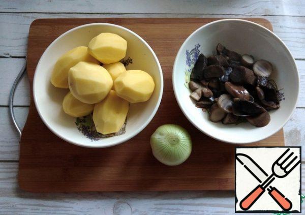Potatoes and onions are cleaned. Mushrooms are fished out of the pan with a slotted spoon, letting the water drain.