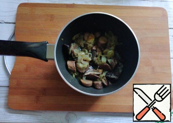 In parallel, fry the onion with boiled mushrooms in a frying pan.