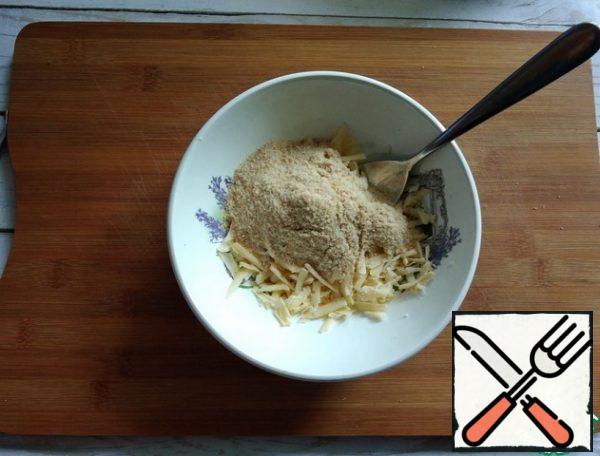Grate the cheese and mix it with breadcrumbs.