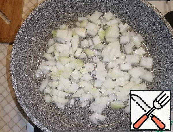 Pour vegetable oil into a preheated frying pan. Add diced onion and fry for 3-4 minutes.