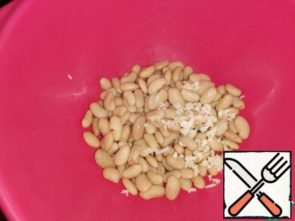 Rinse the beans with boiled water and put them in a colander. Finely chop the garlic or pass it through a press.