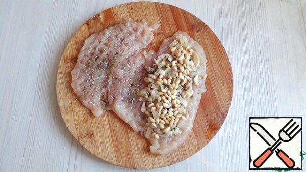 Chicken breasts (2 pcs.) are not cut lengthwise to the end and slightly beat off the inside. Lightly season the breasts with salt and pepper to taste. Add the passioned onions and mushrooms to the chicken breast prepared for baking, add the roasted pine nuts (you can replace them with any nuts).