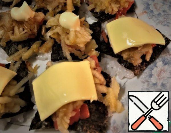 Add mayonnaise.
The next layer is pieces of fish.

Put the grated apple on the fish in a large grater and sprinkle with soy sauce with wasabi.
Add a little more mayonnaise and cheese plates on top.

Because the rice is warm, the cheese gently lies down and covers the island with its corners.