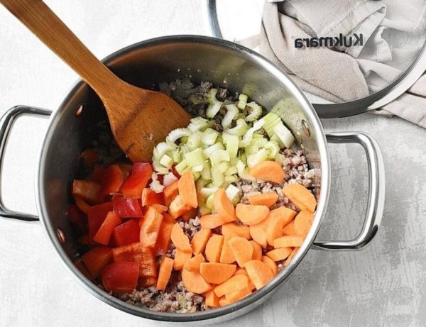 Add carrots, sweet peppers and celery to the pan. Passer for 5 minutes, stirring.