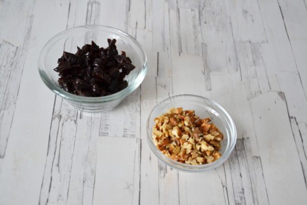 Rinse the prunes and chop them finely. If the prunes are dry, pour boiling water over them and leave for 10 minutes. Then drain the water, pat the dried fruit dry with paper towels, and chop finely. Finely chop the walnuts with a knife or use a blender.

