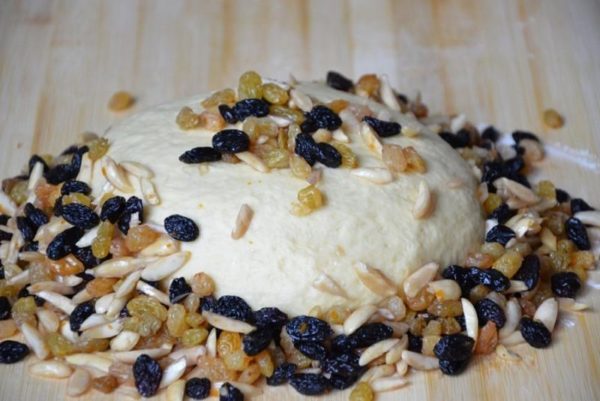 Place the dough on the table and begin incorporating dried fruits and nuts soaked in cognac.


