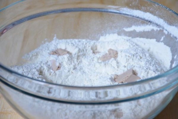 Sift the flour. Add fresh pressed yeast and blend them with flour into fine crumbs. If using new yeast, consider activating it to check for viability. To do this, dilute the yeast in 100 ml of warm water, add 1 tsp sugar, and let the mixture sit for 15 minutes. If a foam cap appears, the yeast is good; if not, there's a possibility the yeast is weak or no longer viable.


