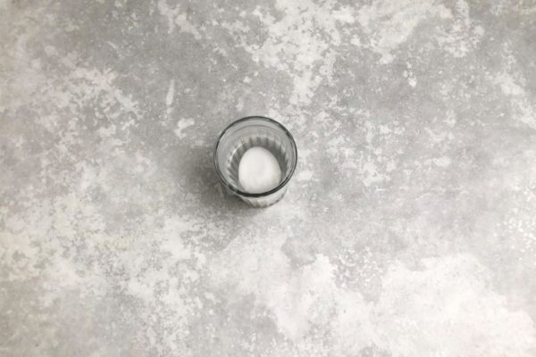 Place the egg in a glass and pour boiling water over it, allowing it to sit for a minute or two. This ensures disinfection without cooking the egg.

