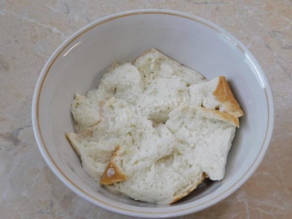 Soak the loaf in milk and let it absorb. Squeeze the milk from the bread and pass it through the meat grinder.


