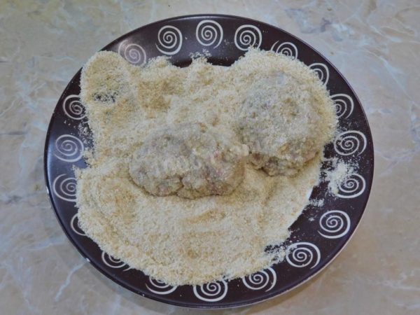 In a separate bowl, spread out some breadcrumbs. Take a small portion of the cutlet mixture, shape it into a patty, and coat it with breadcrumbs.


