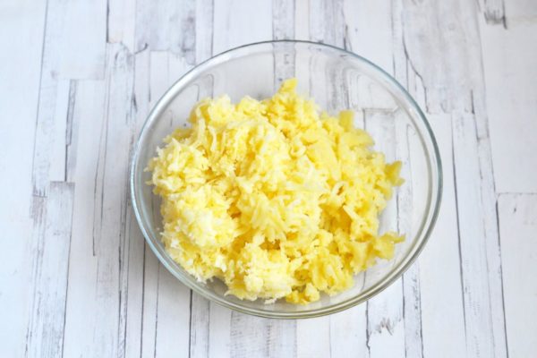 Grate the boiled potatoes using a medium grater.


