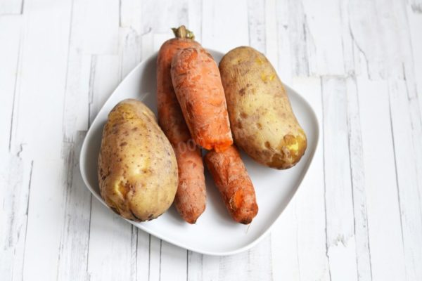 Wash the carrots and potatoes with a brush without peeling them. Boil the vegetables in boiling water until tender. Once cooked, cool and peel.


