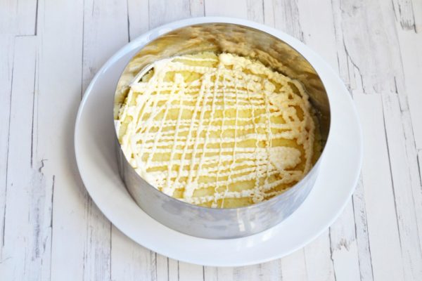 Place a cooking ring (Ø 18-20 cm) on the dish. Arrange the whole potatoes in the first layer, spreading them evenly across the diameter of the ring. Pipe mayonnaise on top. Optionally, you can add a little salt to the layers of potatoes and carrots, although it's not usually added to salads with mayonnaise.



