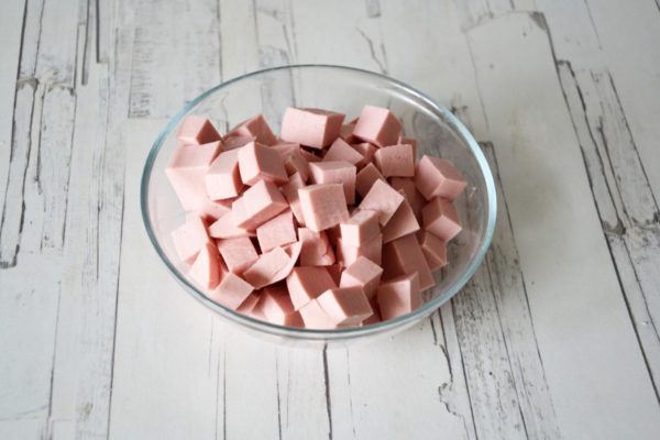 Dice the boiled sausage into cubes. Opting for milk sausage can be a delightful choice.


