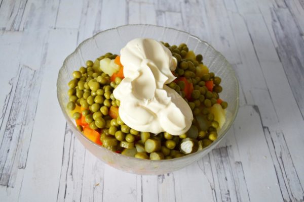 Drizzle the olivier salad with mayonnaise, preferably homemade for a more authentic touch.


