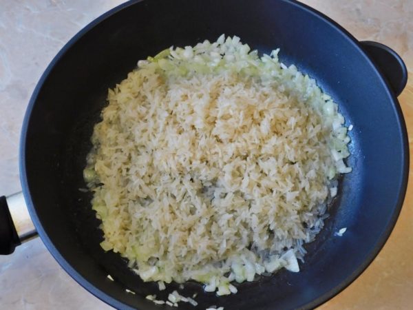 Once the onion is fried, add the washed rice to the pan. Stir and sauté the mixture for 3-4 minutes.


