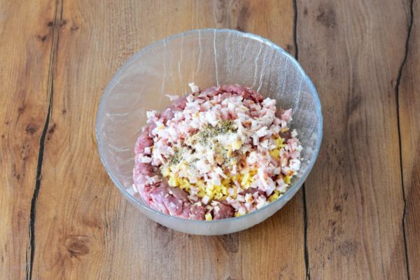 Combine the minced meat, bacon, cheese, vegetable oil, and spices in a bowl. Thoroughly knead the mixture until smooth. For a more homogeneous consistency, you can use a stationary blender to blend the minced meat, cheese, and bacon.


